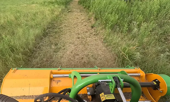 Flail mower cutting heavy brush